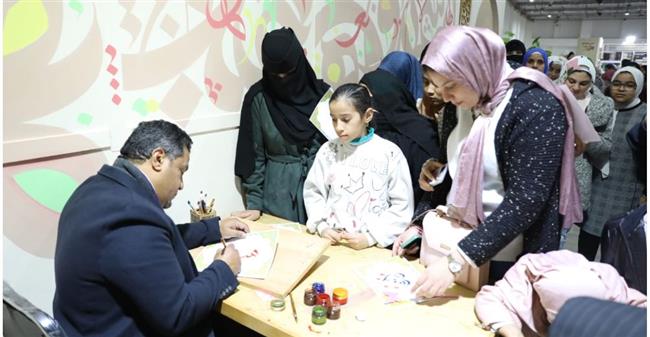 ركن الخط العربي يد تكتب والأخرى ترسم البسمة لزوار جناح الأزهر بمعرض الكتاب