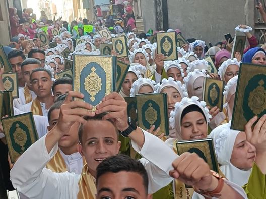 بالفيديو.. أهالي قرية بـ المنيا ينظمون مسيرة لـ270 طفلاً من حفظة القرآن الكريم