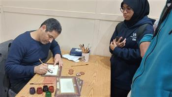   "الخط العربي" يجذب رواد معرض الكتاب في جناح الأزهر