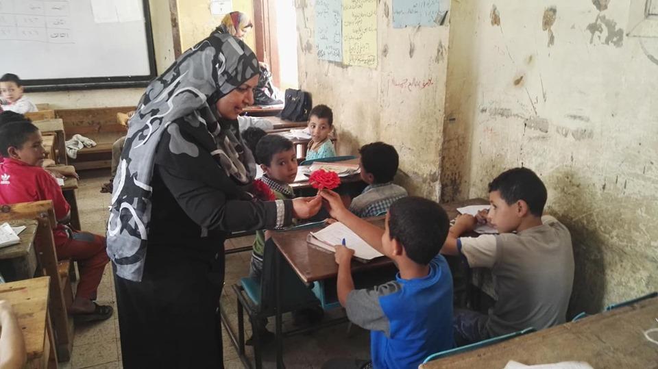   مديرة مدرسة توزع ورد وحلوي علي التلاميذ أثناء امتحان اخر العام ببني سويف