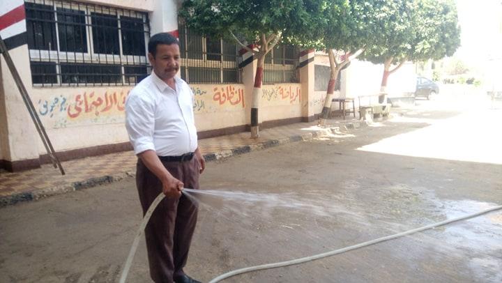   مدير مدرسة يساعد العمال في تنظيف المدرسة أستعدادا للعام الدراسي الجديد ببني سويف